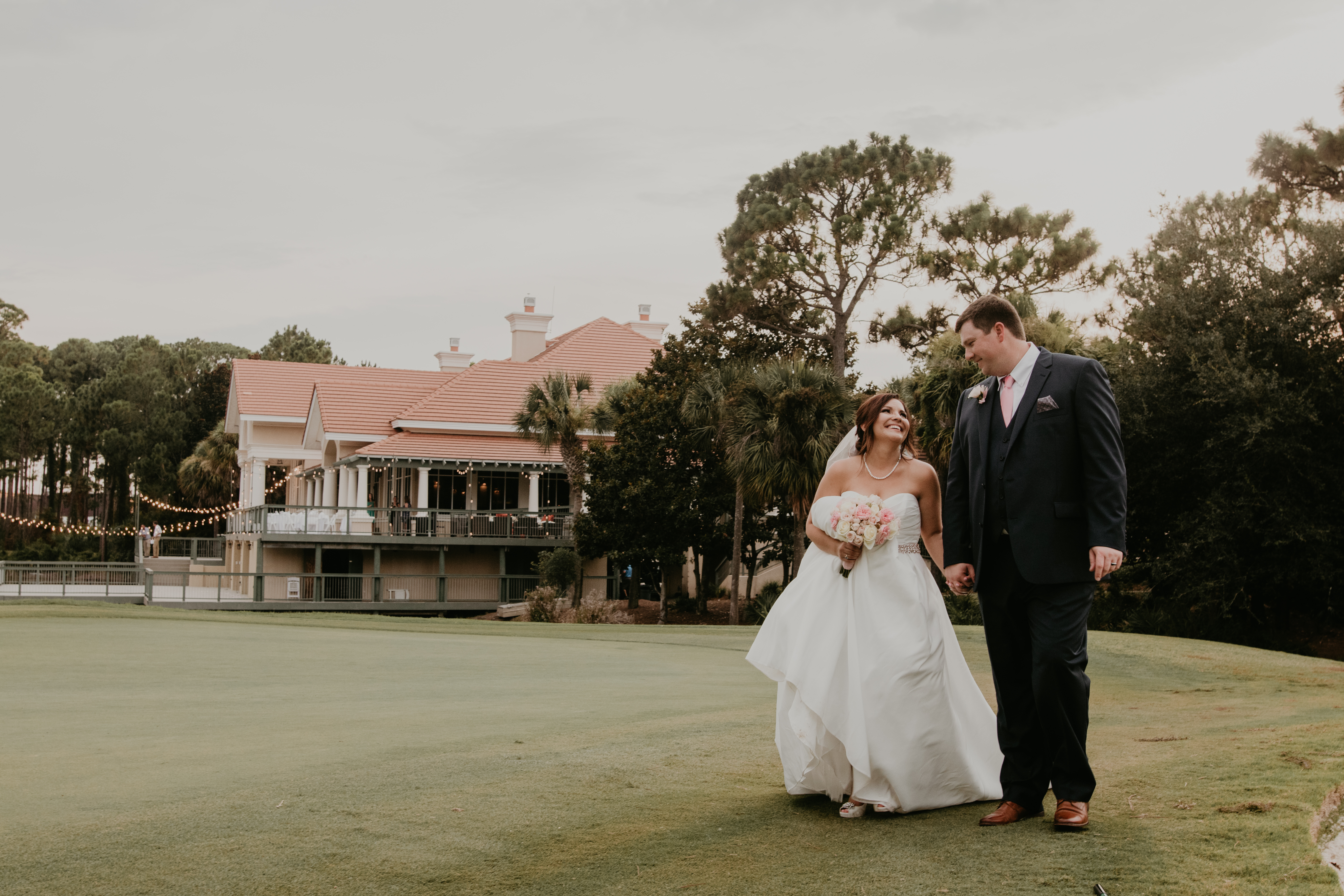 bride and groom walking along golf course